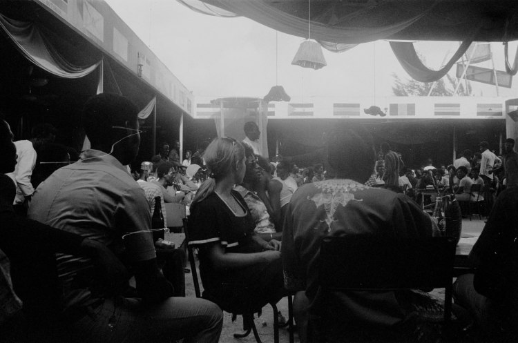 audience seated at the shrine nightclub in the open air girl with pony tail in centre lagos 1978