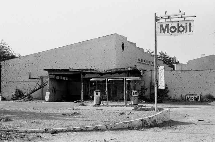 deserted mobil gas station with many bullet holes chad 1982