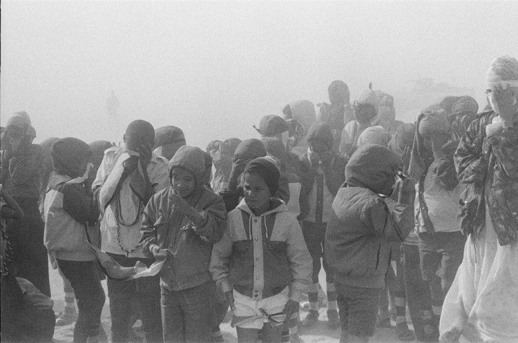 boys talking in crowd of children in sandstorm western sahara 1986