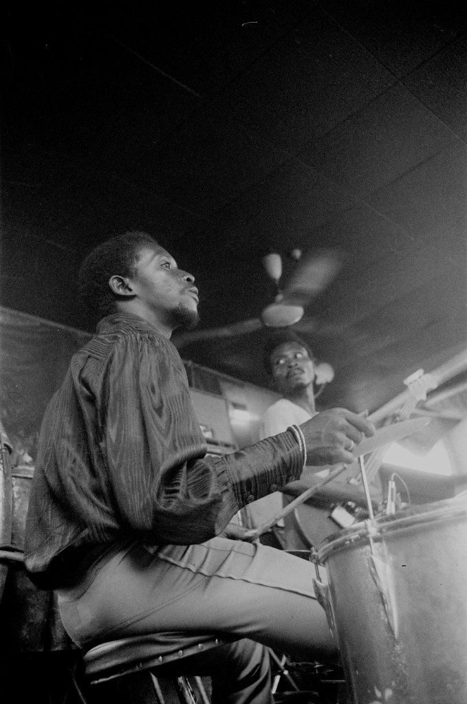 drummer playing on stage in lagos with ceiling fan behind
