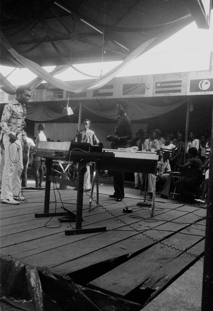 fela kuti with his band on stage smiling percussionist the shrine in lagos 1978