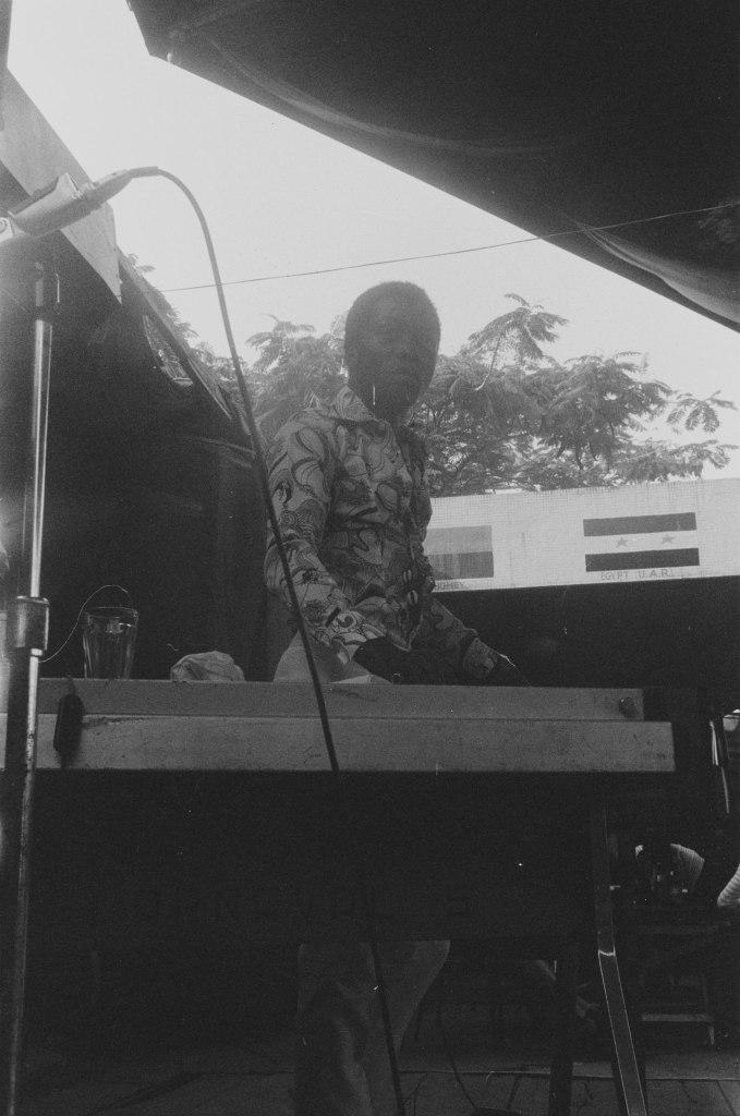 fela at keyboard with sky behind close up