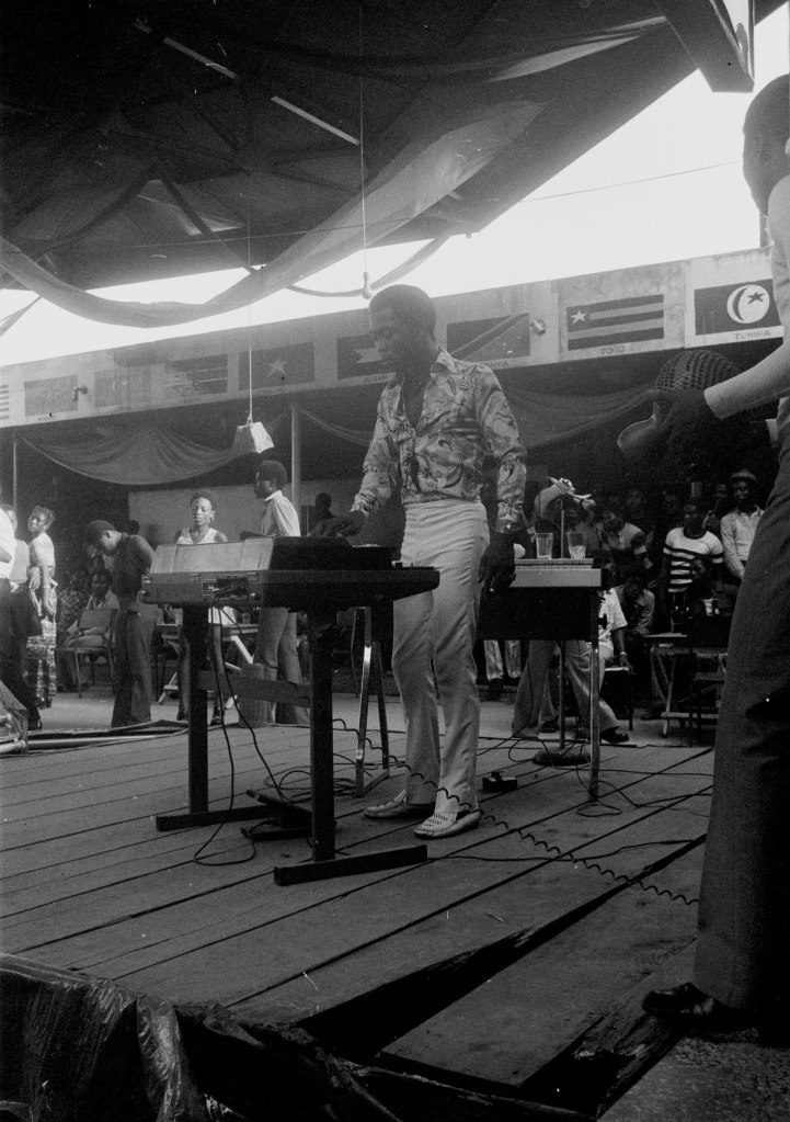 fela kuti white trousers playing keyboard on stage at shrine nightclub 1978