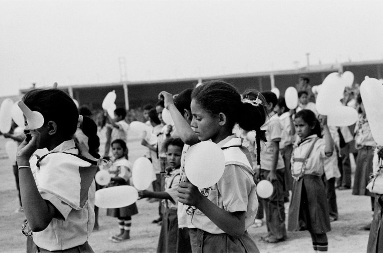 girl with eyes downcast in crowd of uniformed children with white balloons at polisario ten year celebration western sahara 1986