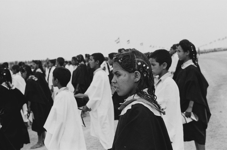 girl with braided hair in crowd polisario ten year celebration western sahara 1986