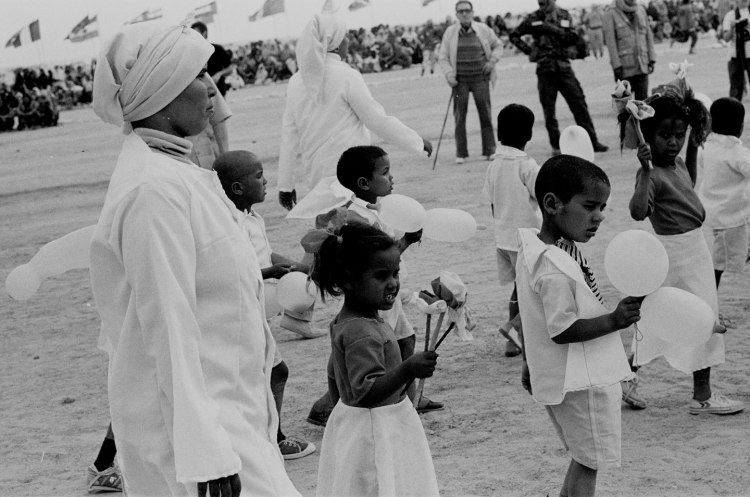 women and children wearing white marching with balloons at polisario ten year celebration western sahara 1986